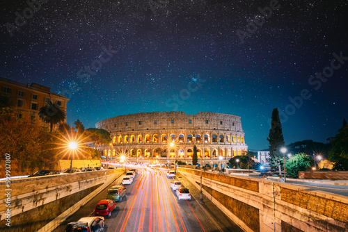 Fototapeta Naklejka Na Ścianę i Meble -  Rome, Italy. Colosseum Also Known As Flavian Amphitheatre In Evening Or Night Time. Night Traffic Light Trails Near Famous World Landmark. Bright Blue Night Sky. Amazing Night Starry Sky Background.