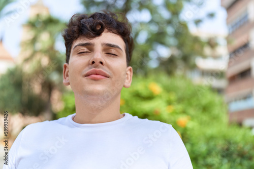 Non binary man breathing with closed eyes at park