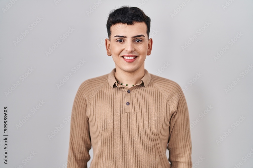 Non binary person standing over isolated background with a happy and cool smile on face. lucky person. Non binary person standing over isolated background with a happy and cool smile on face. lucky person.