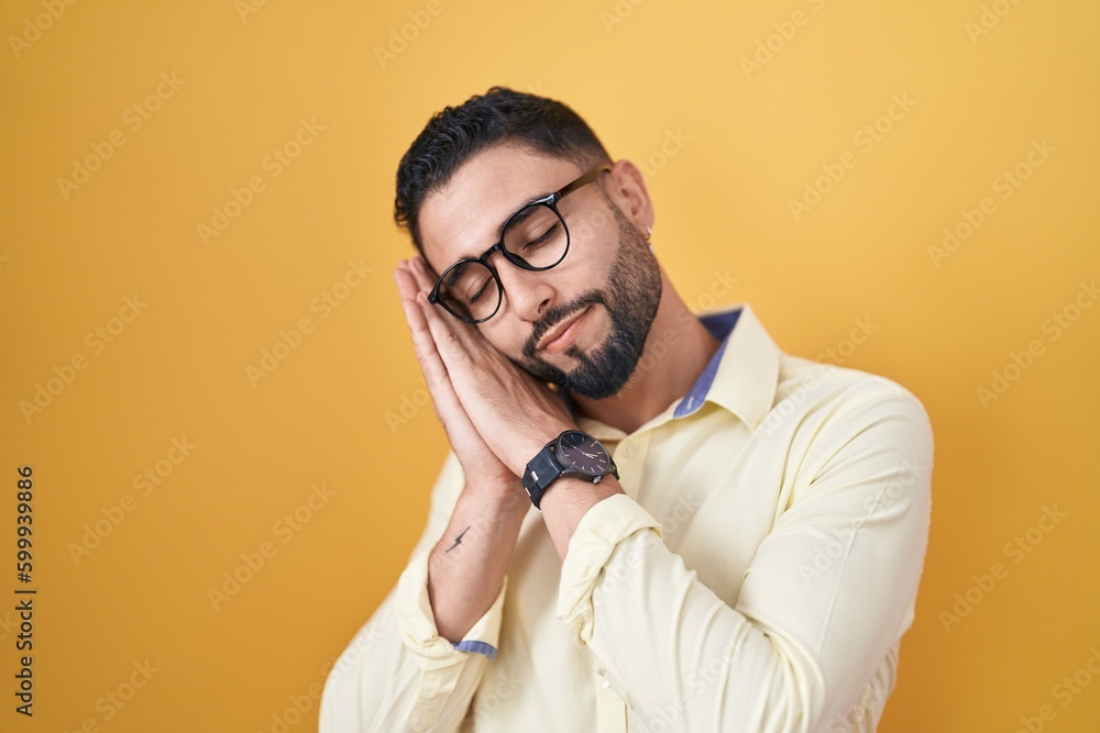Hispanic young man wearing business clothes and glasses sleeping tired dreaming and posing with hands together while smiling with closed eyes. Hispanic young man wearing business clothes and glasses sleeping tired dreaming and posing with hands together while smiling with closed eyes.