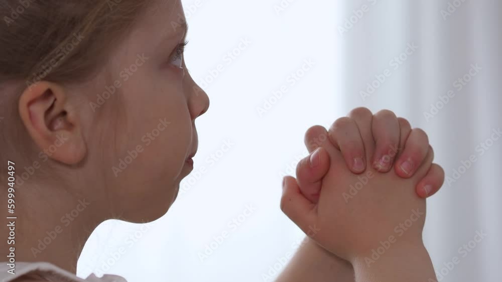 the hands of a small Christian child are folded in prayer. Prayer for ...