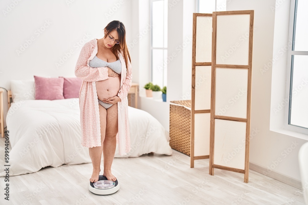 Pregnant woman on weight machine depressed and worry for distress, crying angry and afraid. sad expression. Pregnant woman on weight machine depressed and worry for distress, crying angry and afraid. sad expression.