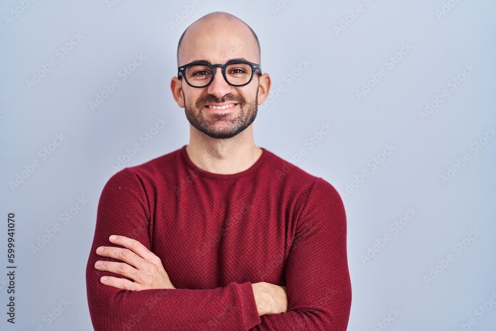 Young bald man with beard standing over white background wearing glasses happy face smiling with crossed arms looking at the camera. positive person. Young bald man with beard standing over white background wearing glasses happy face smiling with crossed arms looking at the camera. positive person.