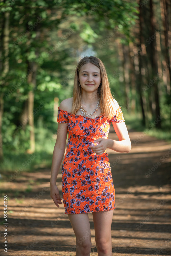 Fototapeta premium Portrait of a young beautiful blonde girl in a summer park.