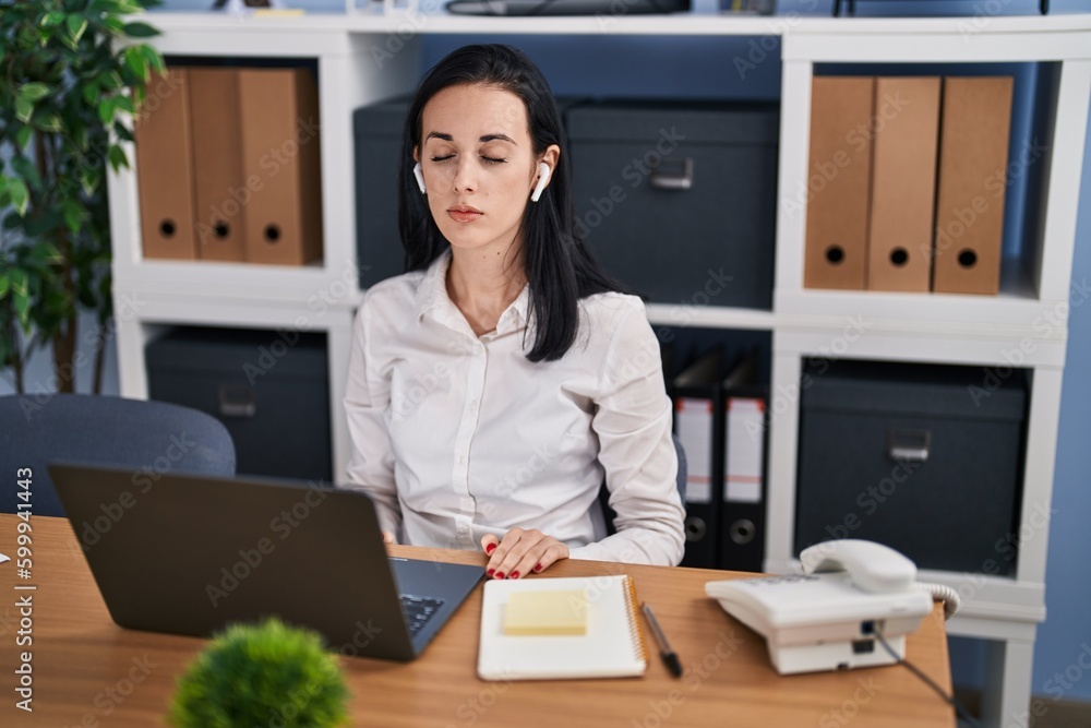 Young caucasian woman business worker using laptop and earphones meditating at office Young caucasian woman business worker using laptop and earphones meditating at office