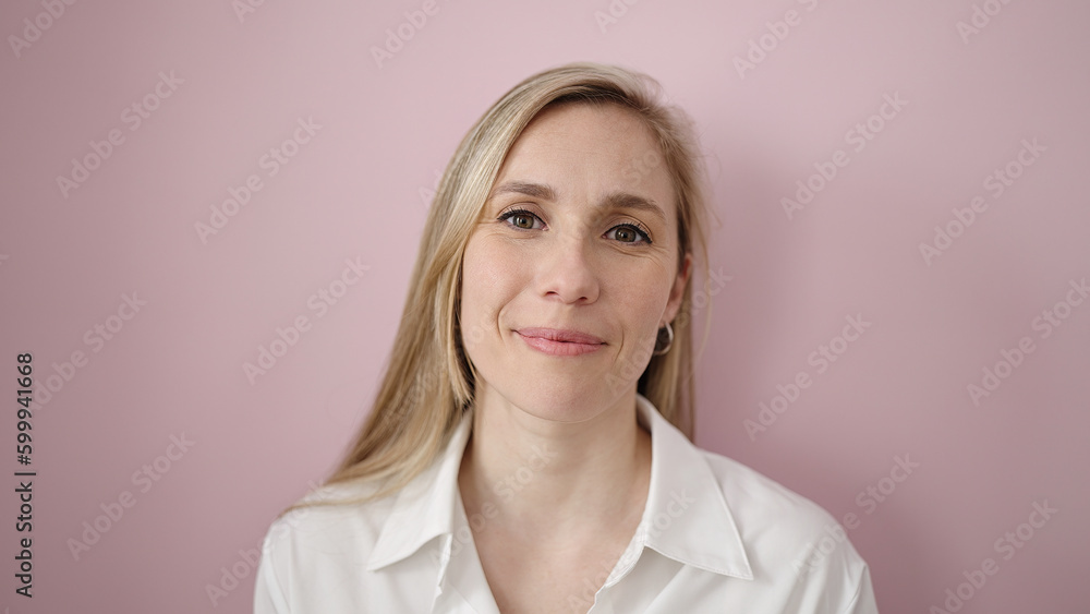 Young blonde woman smiling confident standing over isolated pink background Young blonde woman smiling confident standing over isolated pink background