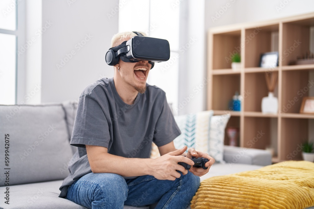 Young caucasian man playing video game using virtual reality glasses at home Young caucasian man playing video game using virtual reality glasses at home