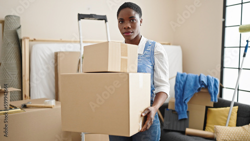 African american woman holding packages at new home