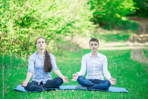 mother and son meditating in nature park
