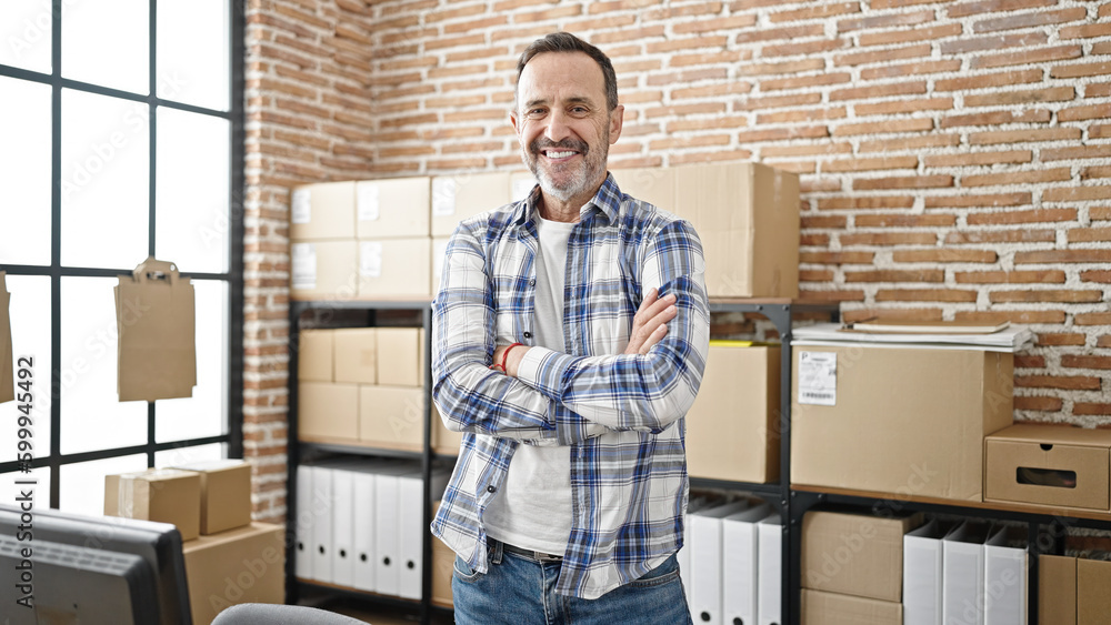 Middle age man ecommerce business worker standing with arms crossed gesture at office Middle age man ecommerce business worker standing with arms crossed gesture at office