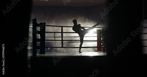 Dedicated athlete doing a shadow fight on boxing ring, practicing muay thai martial art, preparing for a fight - sports, martial arts concept  © andreybiling