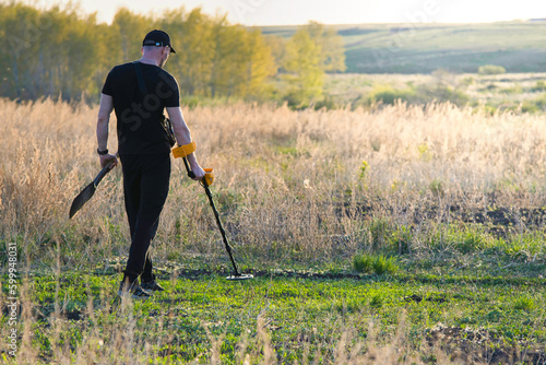 A man with a metal detector is looking for a treasure