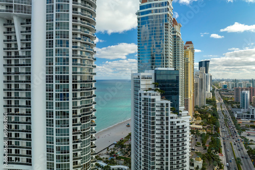Aerial view of Sunny Isles Beach city with luxurious highrise hotels and condos on Atlantic ocean shore. American tourism infrastructure in southern Florida