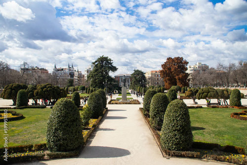 View at Jacinto Benavente statue and Calle de Alfonso XII street at sunny winter day in El Retiro park
