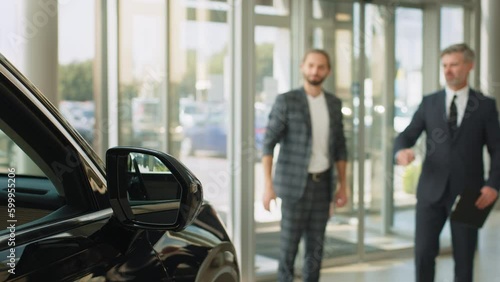 Wallpaper Mural Young successful customer man deciding to buy new auto in showroom. Happy car salesman and male customer in auto dealership, they are shaking hands seal the purchase of the auto or new car Torontodigital.ca