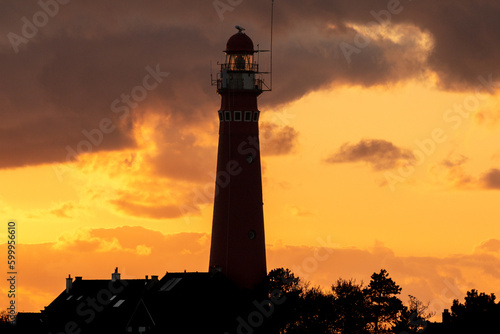 the red lighthouse in Schiermonnikoog  in front of the sunset photo