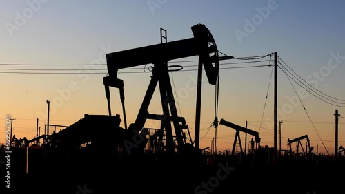 The sun rises behind oil pumps in California