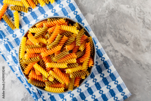 Raw fusilli pasta on concrete. Colorful italian raw pasta on a linen napkin. Italian cuisine