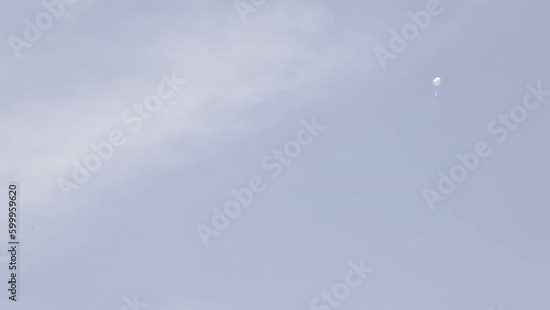 white balloon with strip flying in the blue sky