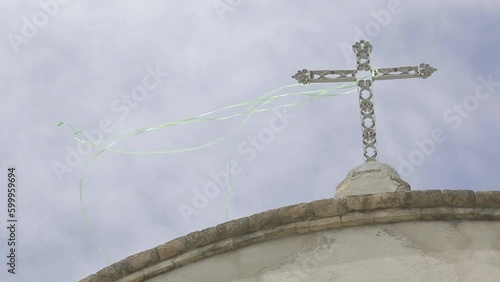 
church cross with tangled colored garlands and blue sky