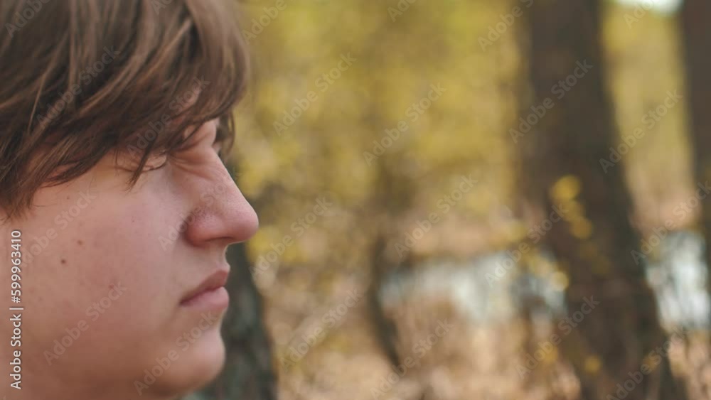 A guy spends time alone in nature. Solitude and thoughts about life. Depressed young man alone with himself. Soft selective focus. A guy spends time alone in nature. Solitude and thoughts about life. Depressed young man alone with himself. Soft selective focus.