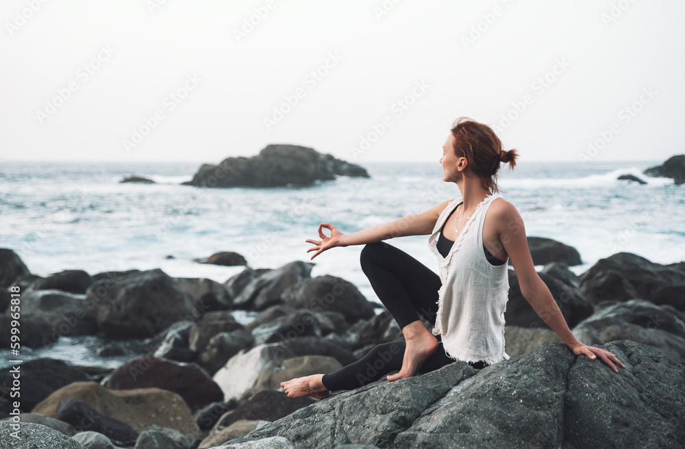 Woman practicing yoga on the beach. Active Travel Healthy Yoga Lifestyle.