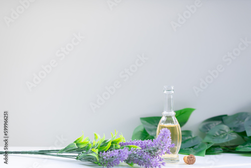 Essential oil glass bottle, lavender flowers in frontand leaves in the background. Aromatherapy, natural remedies