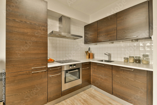 a kitchen with wood cabinets and white tiles on the walls, along with a stainless dishwasher in the corner