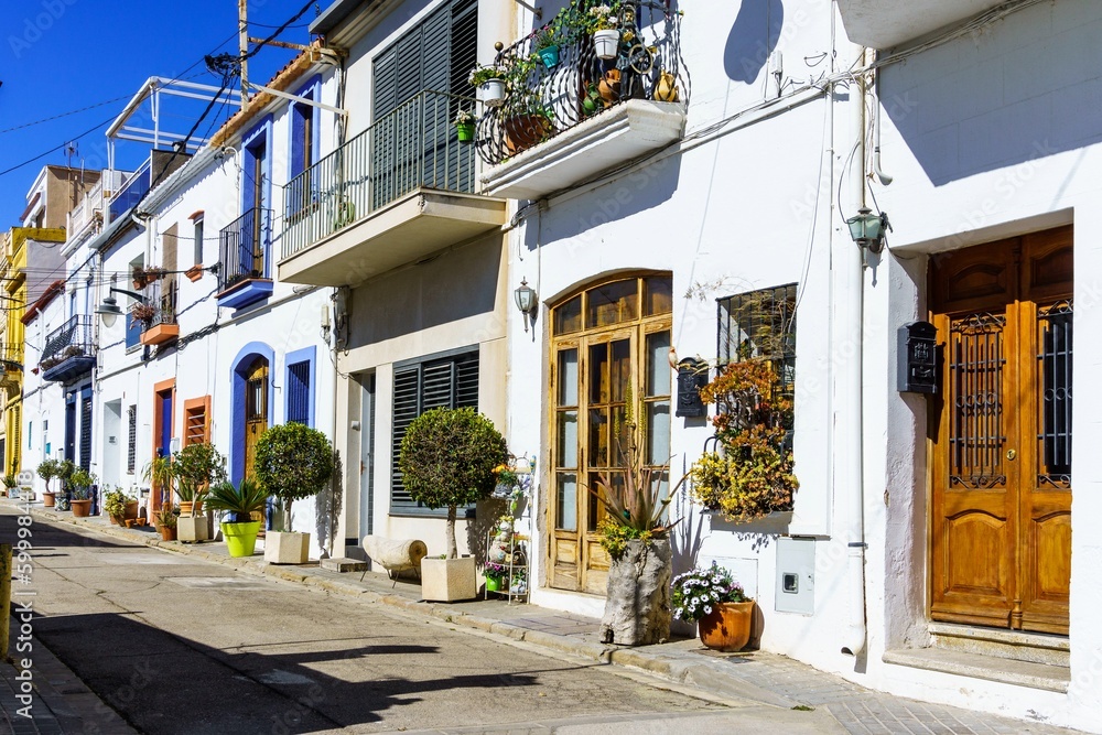 A picturesque village with a beautiful Mediterranean houses, its striking facade illuminated in the bright days light. Its windows invitingly open to the city neighborhood