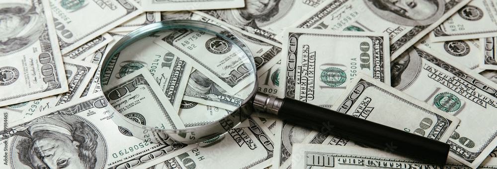 Dollar bills and a magnifying glass Dollar bills and a magnifying glass