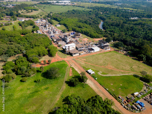Aerial image of chemical industry. Large structure of pipelines and warehouses with movement of cargo trucks. Industry surrounded by vast vegetation and trees. Located in Brazil  city of Paul  nia.
