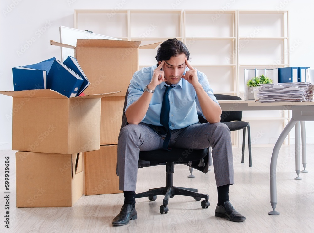 Young man employee with boxes in the office Young man employee with boxes in the office