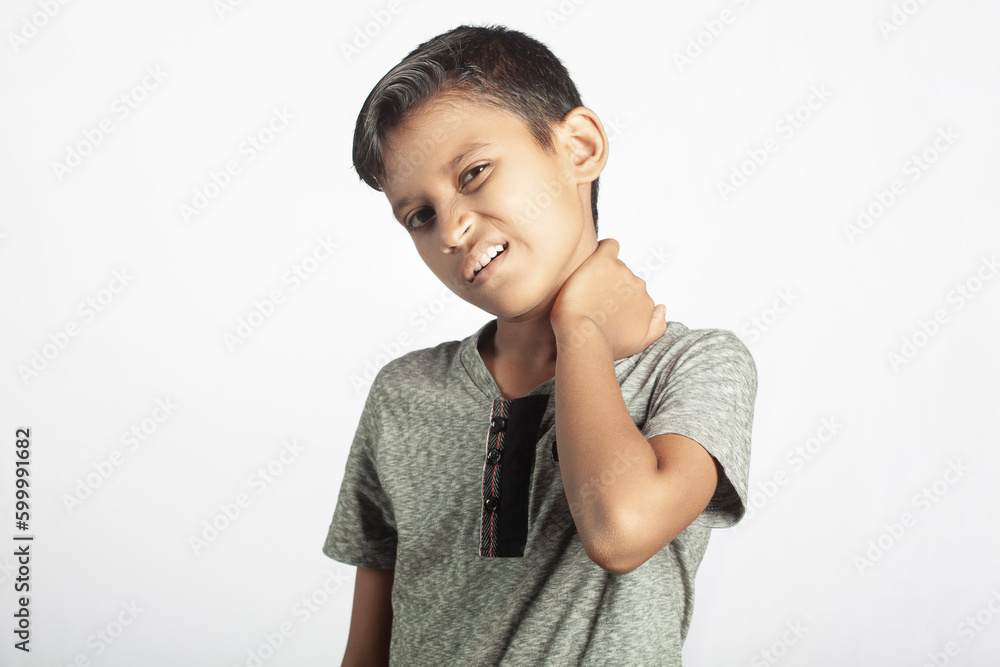 indian ethnicity boy holding his neck with pain in white background indian ethnicity boy holding his neck with pain in white background