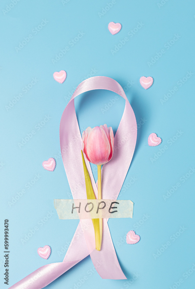 One pink ribbon with hearts and a tulip on a blue background. One pink ribbon with hearts and a tulip on a blue background.