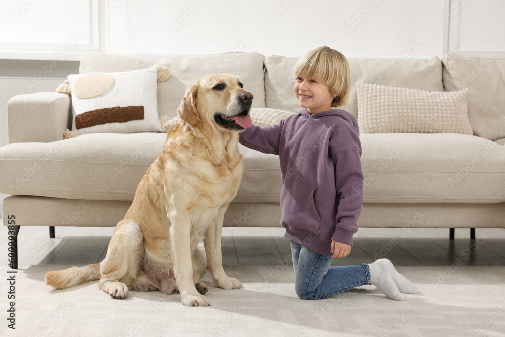 Cute little child with Golden Retriever on floor at home. Adorable pet Cute little child with Golden Retriever on floor at home. Adorable pet