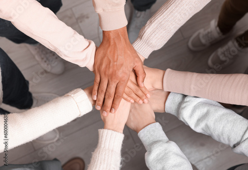 Group of multiracial people joining hands together indoors, top view © New Africa