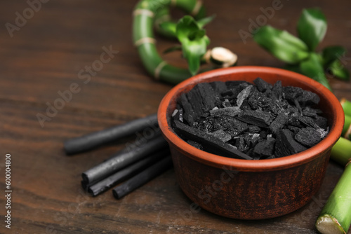 Fresh bamboo and charcoal on wooden table, closeup. Space for text