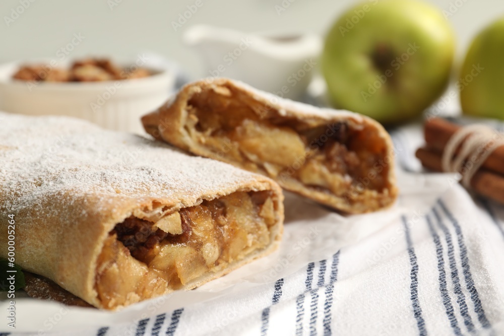 Delicious strudel with apples, nuts and powdered sugar on table, closeup. Space for text Delicious strudel with apples, nuts and powdered sugar on table, closeup. Space for text