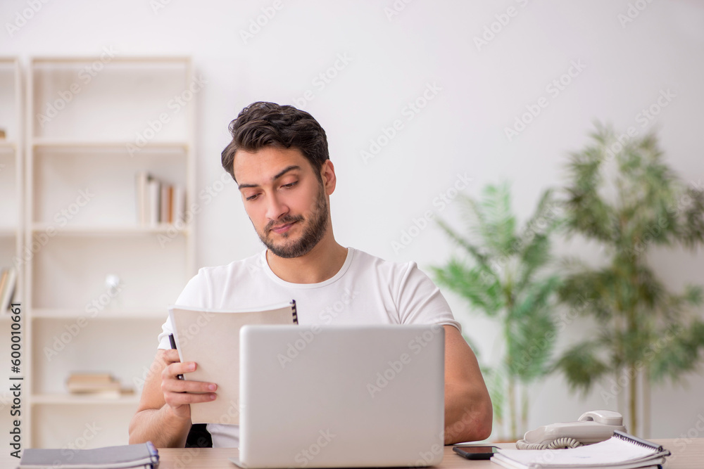 Young male employee working in the office Young male employee working in the office