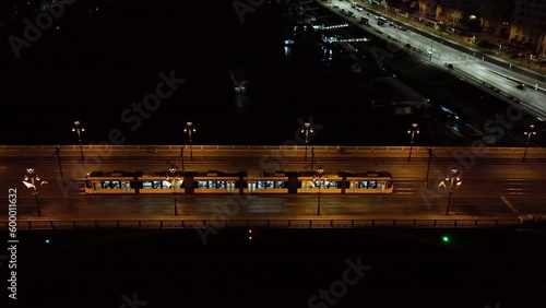 Aerial view of Budapest Margaret Bridge or Margit hid over River Danube, embankment at night. Public transport in the city. Yellow tram passing through the bridge