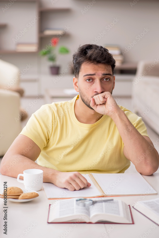 Naklejka premium Young male student studying at home