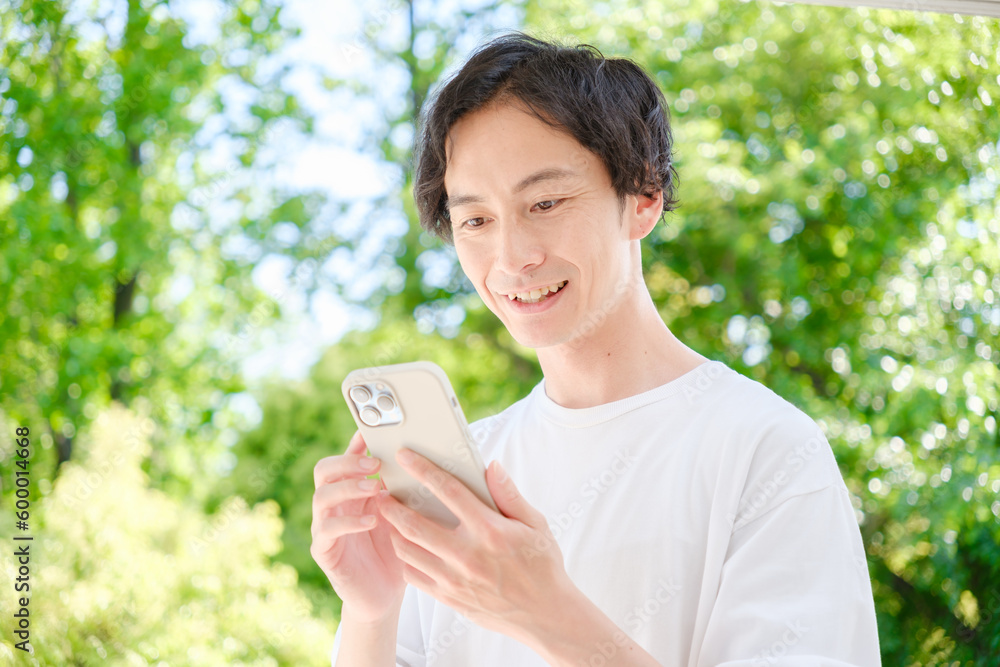 スマートフォンを使う若い男性 スマートフォンを使う若い男性