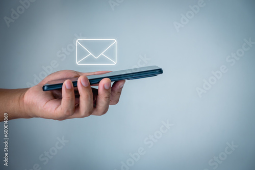 Email marketing and newsletter. Customer service call center contact us. Male hand holding letter icon, email icons. Contact us by newsletter email and protect your personal information from spam mail photo