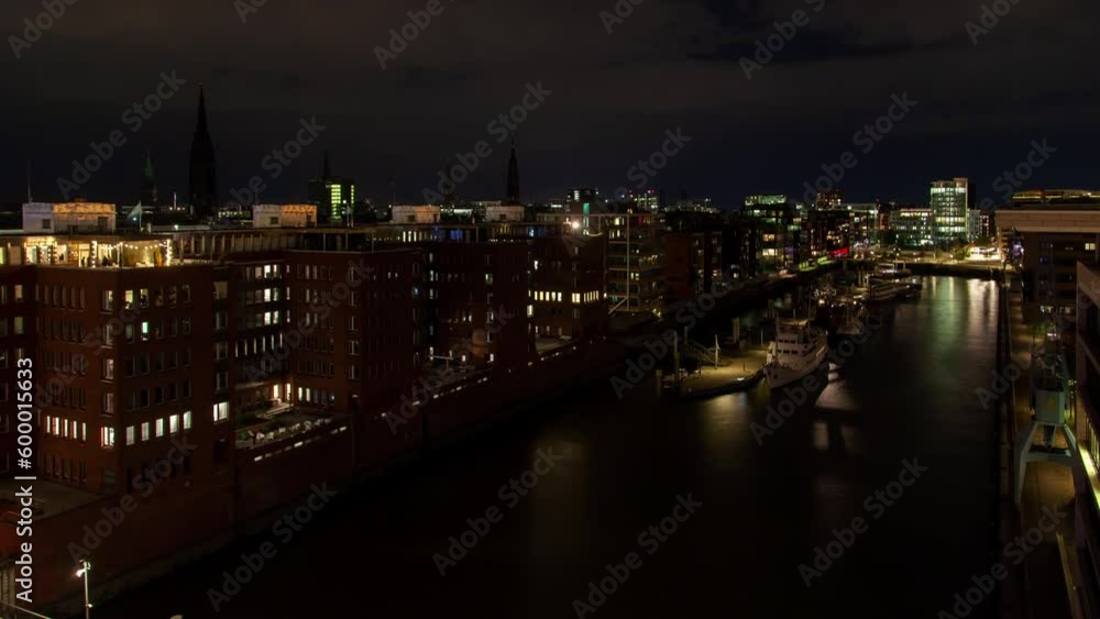 Night timelapse of Hamburg's wealthy district skyline, featuring a marina with yachts at the pier along a canal in an urban residential area. Night timelapse of Hamburg's wealthy district skyline, featuring a marina with yachts at the pier along a canal in an urban residential area.