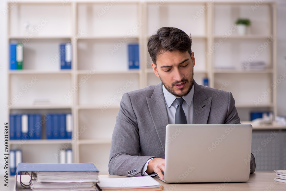 Young male employee working in the office Young male employee working in the office