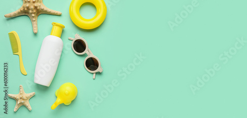 Sunscreen cream and beach accessories for child on turquoise with space for text