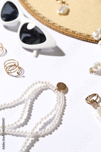 Jewelry with sunglasses and hat on white background, closeup