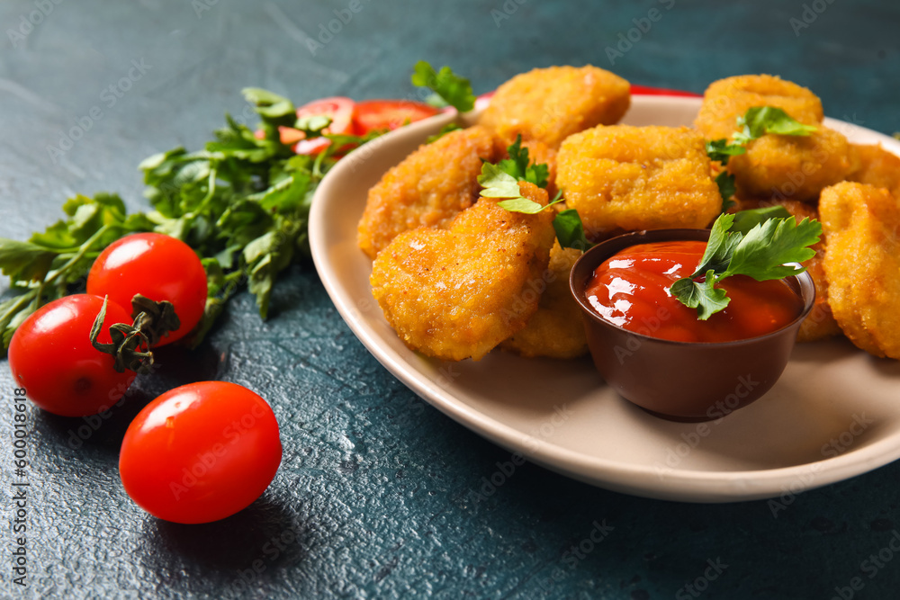 Plate with delicious nuggets, ketchup and parsley on dark blue table