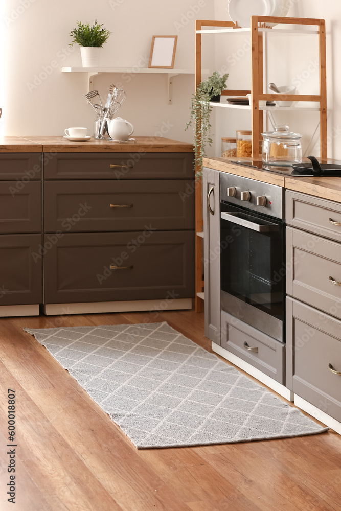 Stylish grey rug on floor in kitchen Stylish grey rug on floor in kitchen