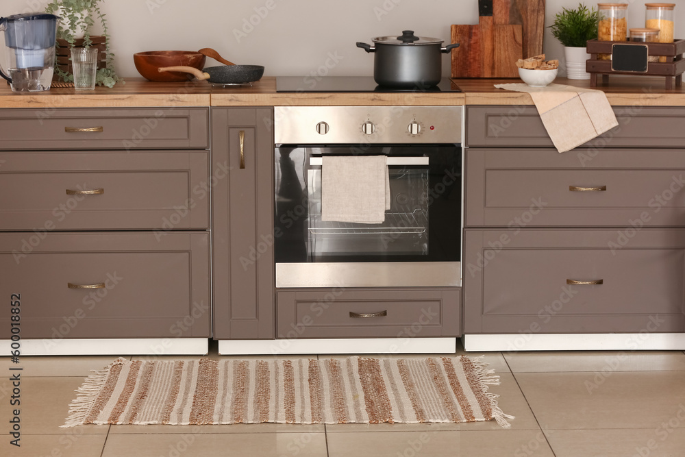 Stylish rug on floor in kitchen Stylish rug on floor in kitchen